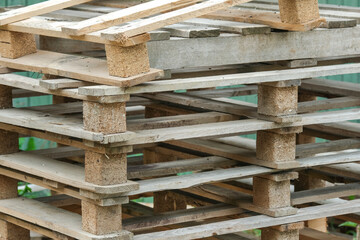 Konzept Recycling oder Entsorgung: Mehrere Euro Paletten aus Holz drau&szlig;en gestapelt - selektiver Fokus