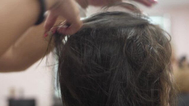 Hairdresser drying woman hair slow motion