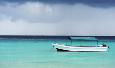 Fototapeta na wymiar A fishing boat in the Indian Ocean against the backdrop of an approaching storm.ZANZIBAR - TANZANIA