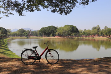 Vélo devant un lac du parc historique de Sukhothaï, Thaïlande