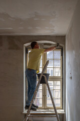  craftsman plastering a lintel with mortar on a building site.