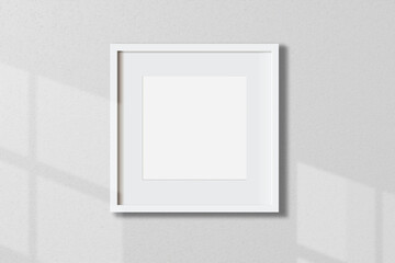 Minimal empty square white frame picture mock up hanging on white wall background with window light...