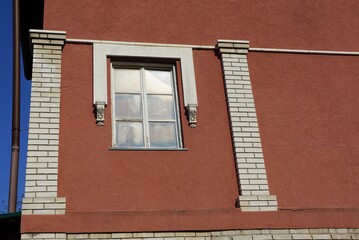 one white window on the brown wall of a private house