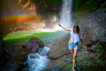 Young woman near going Aling Aling waterfall, Bali, Indonesia