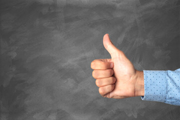 like gesture on gray textured background. thumbs up. positive concept
