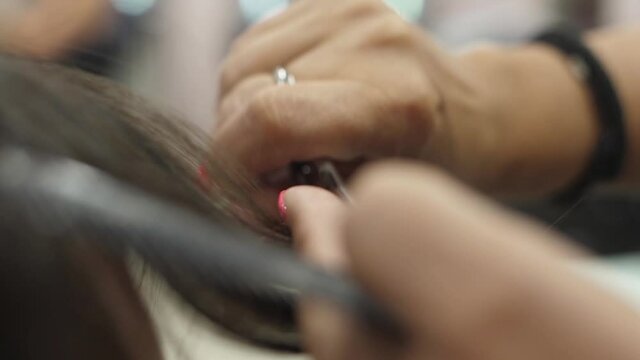 Hairdresser cutting woman hair with scissors slow motion