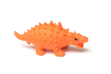 Closeup of orange color plastic dinosaur toy on white background