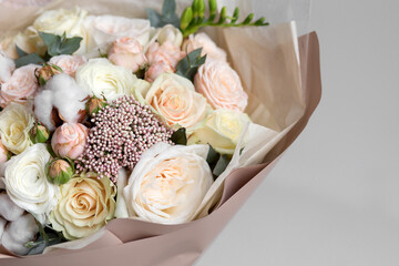 Spring pastel bouquet with roses closeup in craft paper. Flower wallpaper. Background.