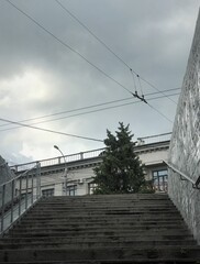 steps from the underpass against the sky with clouds and buildings