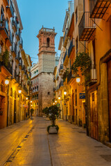 Fototapeta na wymiar Sunrise view of Carrer dels Serrans street leading to Torre de Sant Bartomeu tower in Valencia, Spain