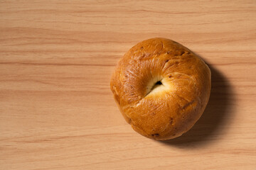 Morning breakfast bagel bread with blank space on a wooden background.