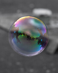 Rainbow iridescent soap bubble on plain background