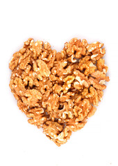 Heart made with organic walnuts isolated on white background.