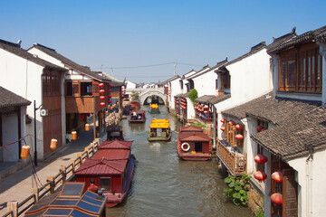 a canal with boats in the old town of suzhou and sunny blue sky