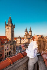 young woman with a cocktail on the roof in the center of Prague overlooking the Old Town Square