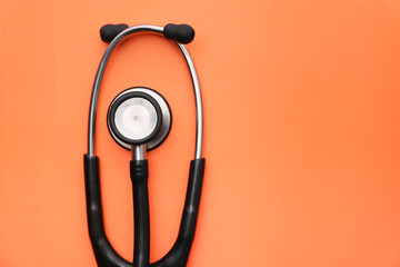 high angle view of red stethoscope on orange background.