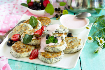 Summer breakfast. Homemade cottage cheese pancakes with poppy seeds, sour cream sauce with strawberries.