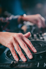 DJ Hands creating and regulating music on dj console mixer in concert nightclub stage.