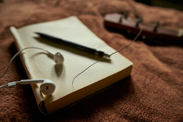 Prop composing music with headphones and books and pens and guitars