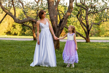 Obraz na płótnie Canvas Bride with a child walks in the park