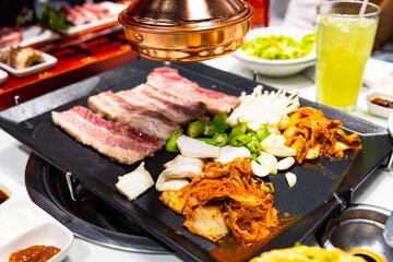 Korean BBQ Raw Pork on the Grill with Kimchi.