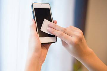 woman is cleaning cell phone