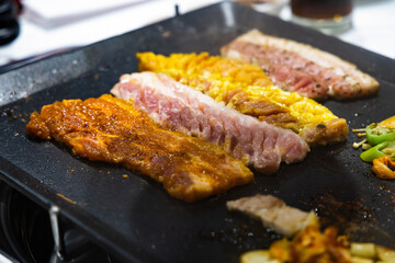 Korean BBQ Raw Pork on the Grill with Kimchi.