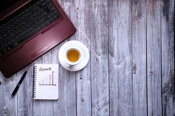 hand drawing financial graph on notepad with tea and pen on table 