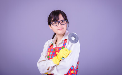 Asian Woman cleaning and polishing the kitchen worktop with a spray detergent, housekeeping and hygiene concept, accessories studio shot isolated on Gray background 