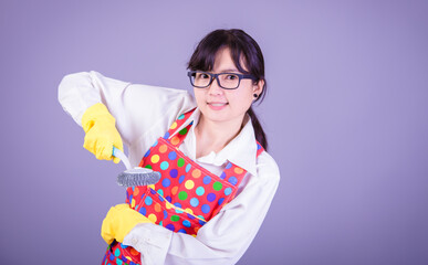 Asian Woman cleaning and polishing the kitchen worktop with a spray detergent, housekeeping and hygiene concept, accessories studio shot isolated on Gray background 