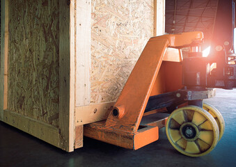 Shipment wooden crate and hand pallet truck.