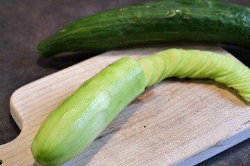 Concombre émincé sur une planche.
