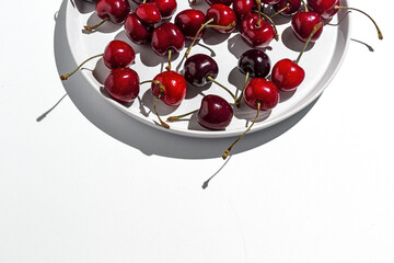 Fresh seasonal red cherries in strong sunlight