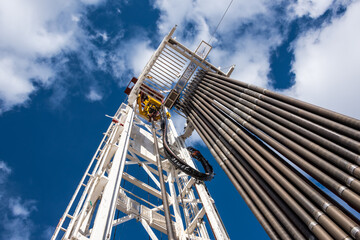 Oil rig derrick in oilfield against the bright blue sky