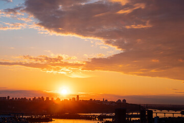 Beautiful sunset sky with clouds over city skyline background. Kyiv city. Ukraine. © stone36