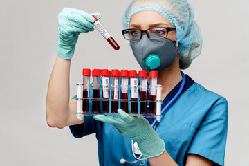 medical doctor nurse woman wearing protective mask and gloves - holding rack with virus blood tests