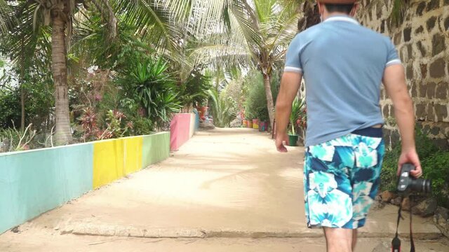 Africa: tourist walking at the colorful street of Ngor island, Dakar, Senegal