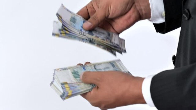 Business man in a suit counting 100 soles bills. Peruvian currency concept, counting bank notes from Peru. Executive hispanic male holding one hundred notes.