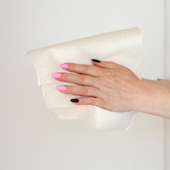 a woman wipes her wet hands with a paper white disposable towel