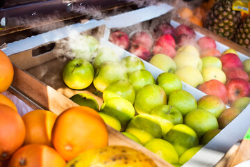 fruits are sold on the market. red and green apples, oranges and pineapples. cooled by air supply. bazaar
