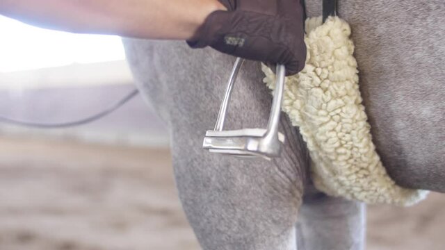 putting foot on saddle to ride horse slow motion