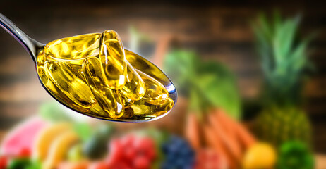 Capsules of Omega 3 oil on natural vegetable background.