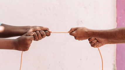 black ethnicity arms with hands pulling rope against white Caucasian race person in stop racism and xenophobia concept, immigration and multiracial respect isolated on white background