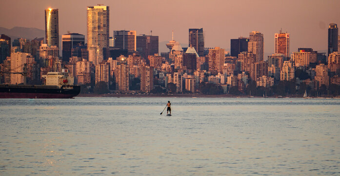 paddle boarder in front of Vancouver skyline