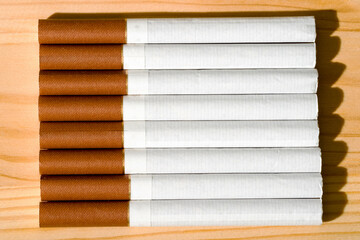 Close-up of a row of cigarettes on a wooden table.