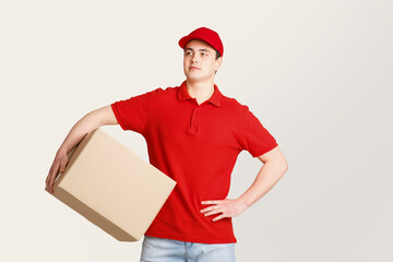 Deliveryman expectation customer at door. Courier looks at free space and holds big box under his...