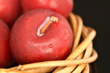 Fresh ripe, organic red plum, close-up, on a black background.