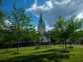 Fototapeta na wymiar Church in sunny daylight in green with blue skyes and clowds