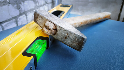 Hammer and level tool at building site.