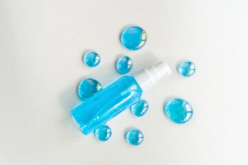 Blue gel spray, drops, glass, on a white background, top view.